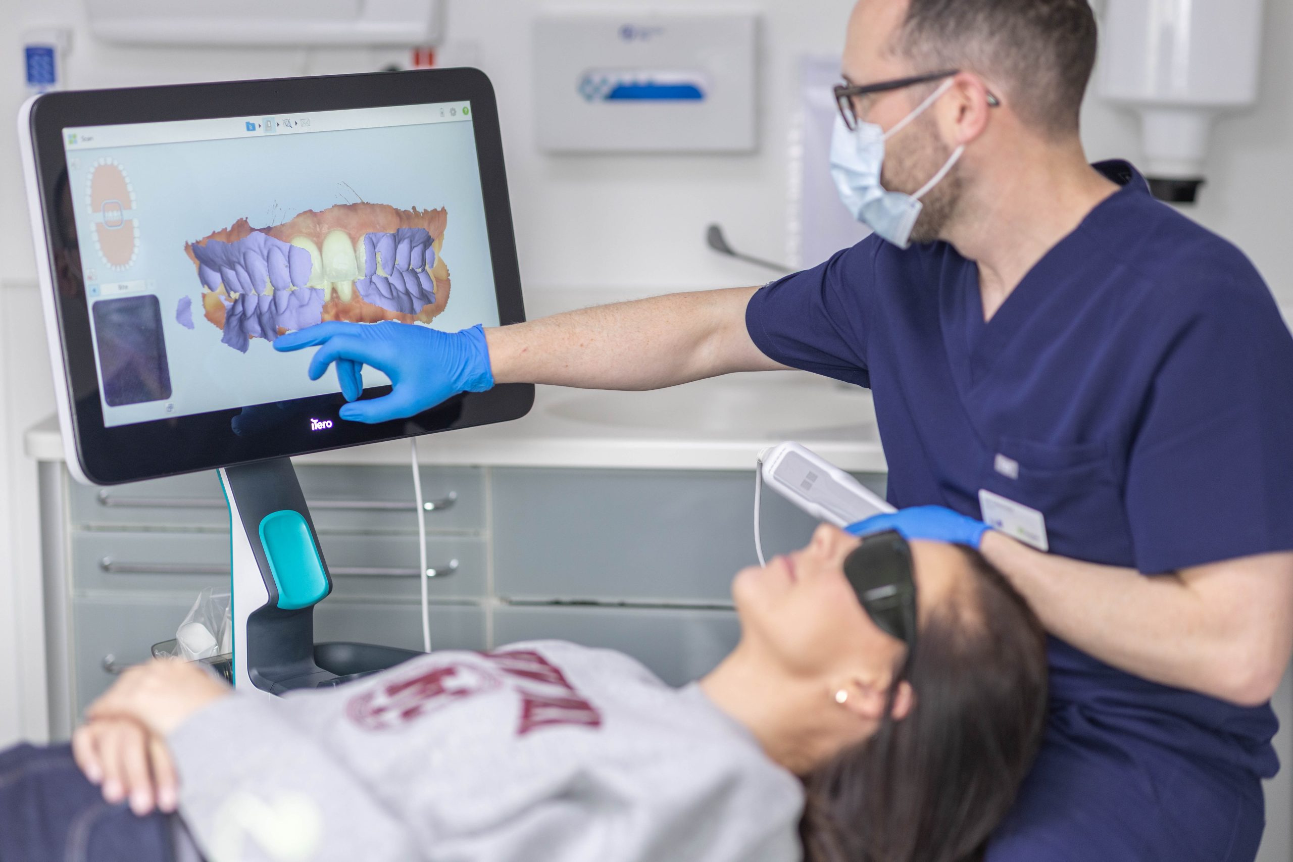 Macro photograph of a 3D intraoral scanner capturing dental impressions with blue laser light
